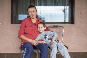 September 2023, mykolaiv, ukraine. a mother sits with her son on the patio of the shelter where they are staying.