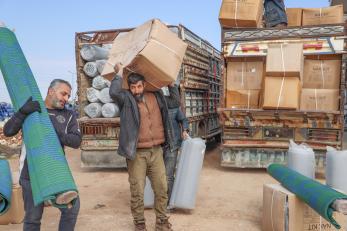 People unloading kits for families affected by the earthquake in northwest syria.