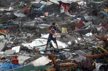 A person is pictured standing in a salvage yard in a rainstorm