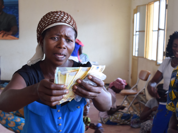 A woman in dr congo holds cash in her hands