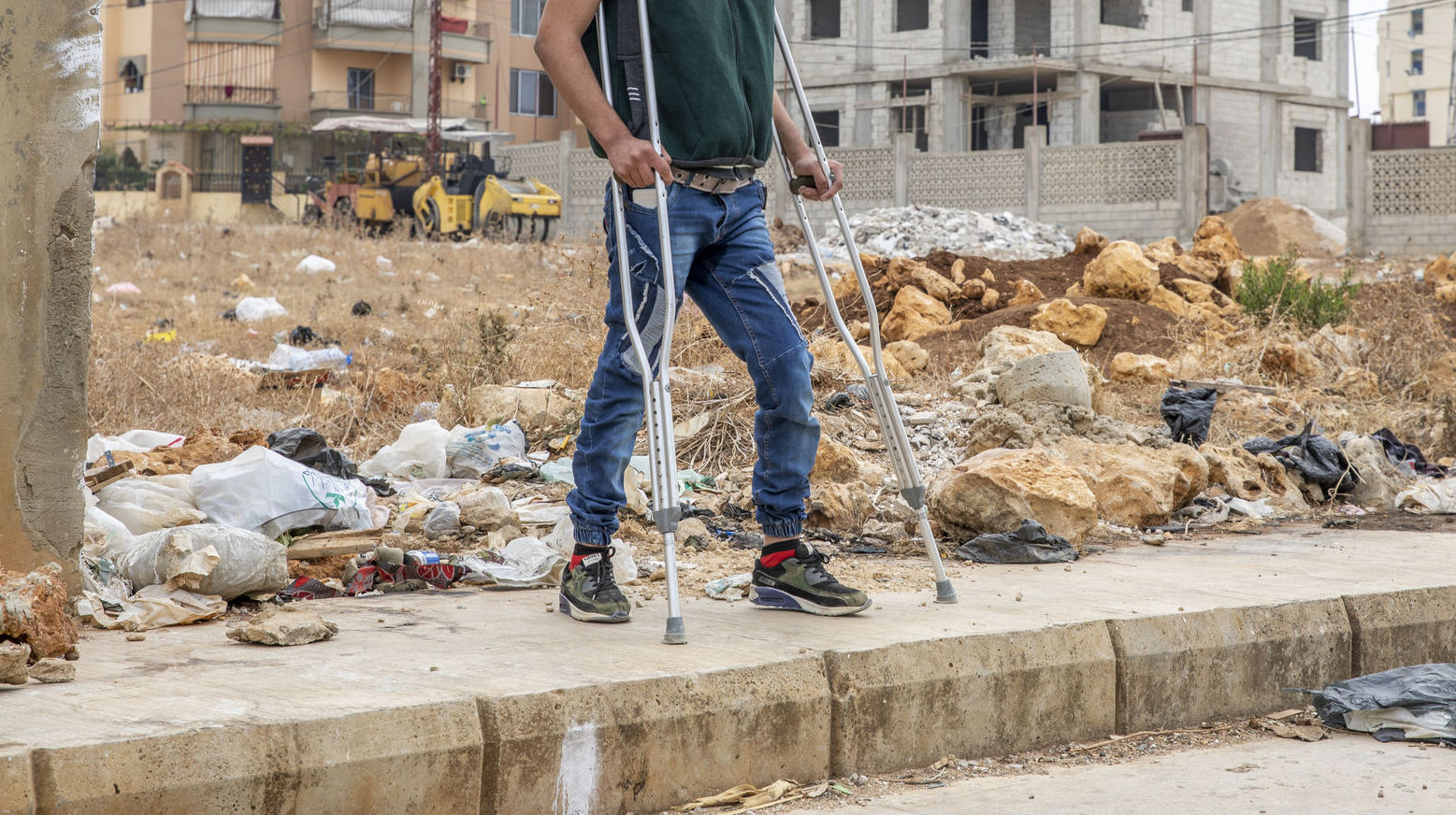 disabled individual standing in front of empty lot.