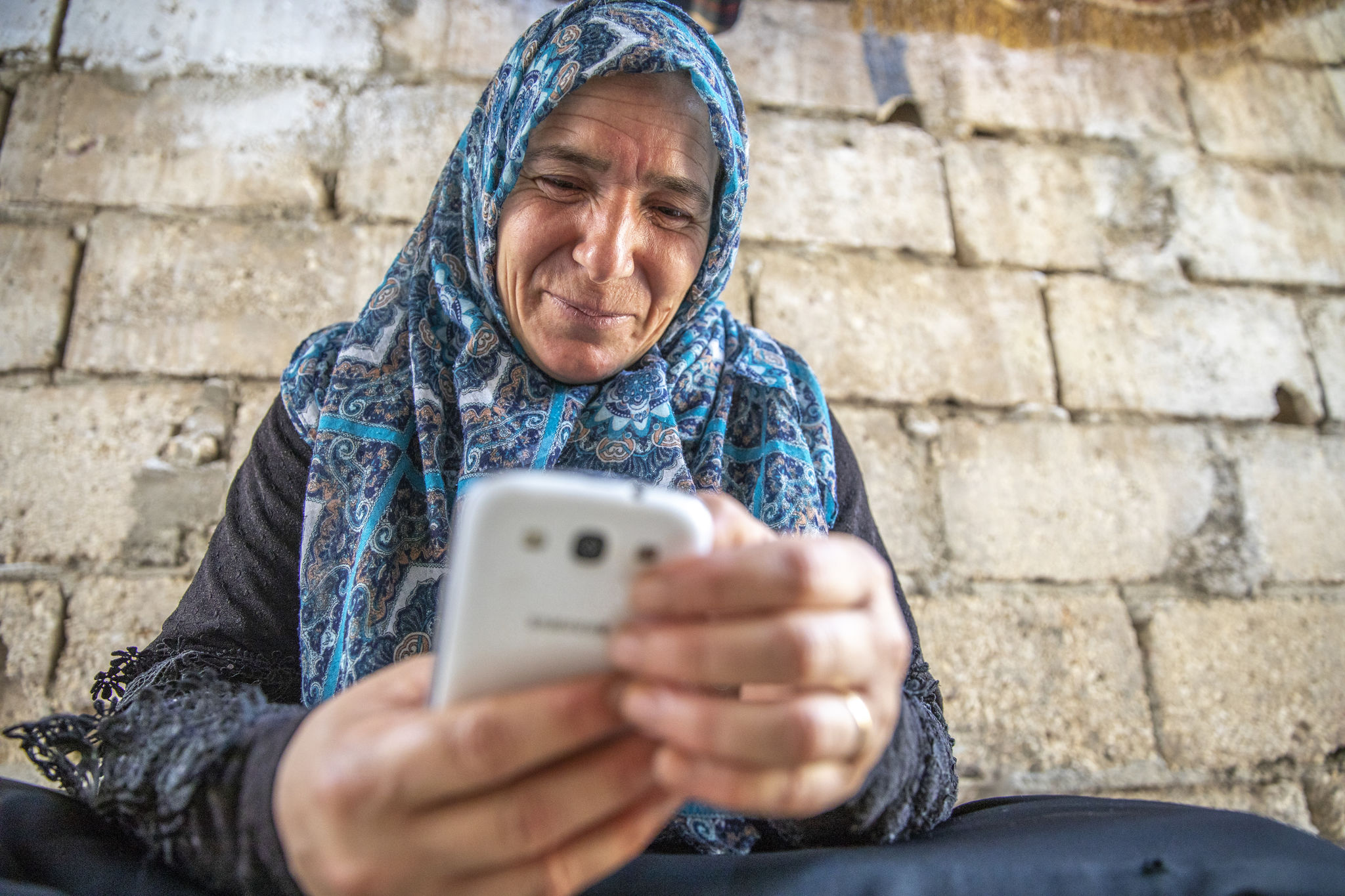 A Syrian refugee uses her mobile phone to access digital banking services in Jordan.