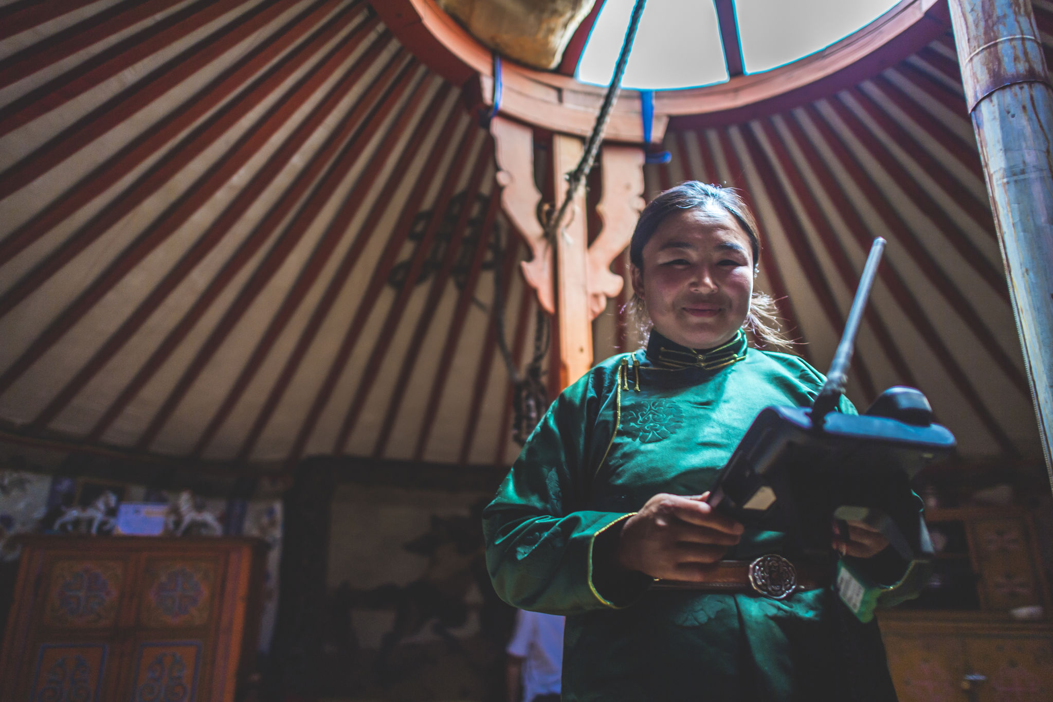 A Mongolian animal herder uses an SMS forecasting system device to monitor local weather.