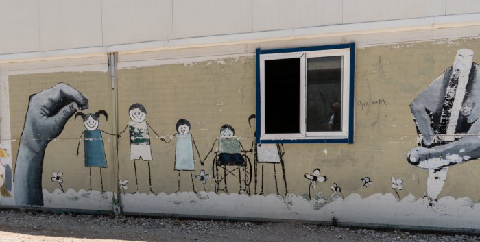 A wall painted with a mural of children holding hands.