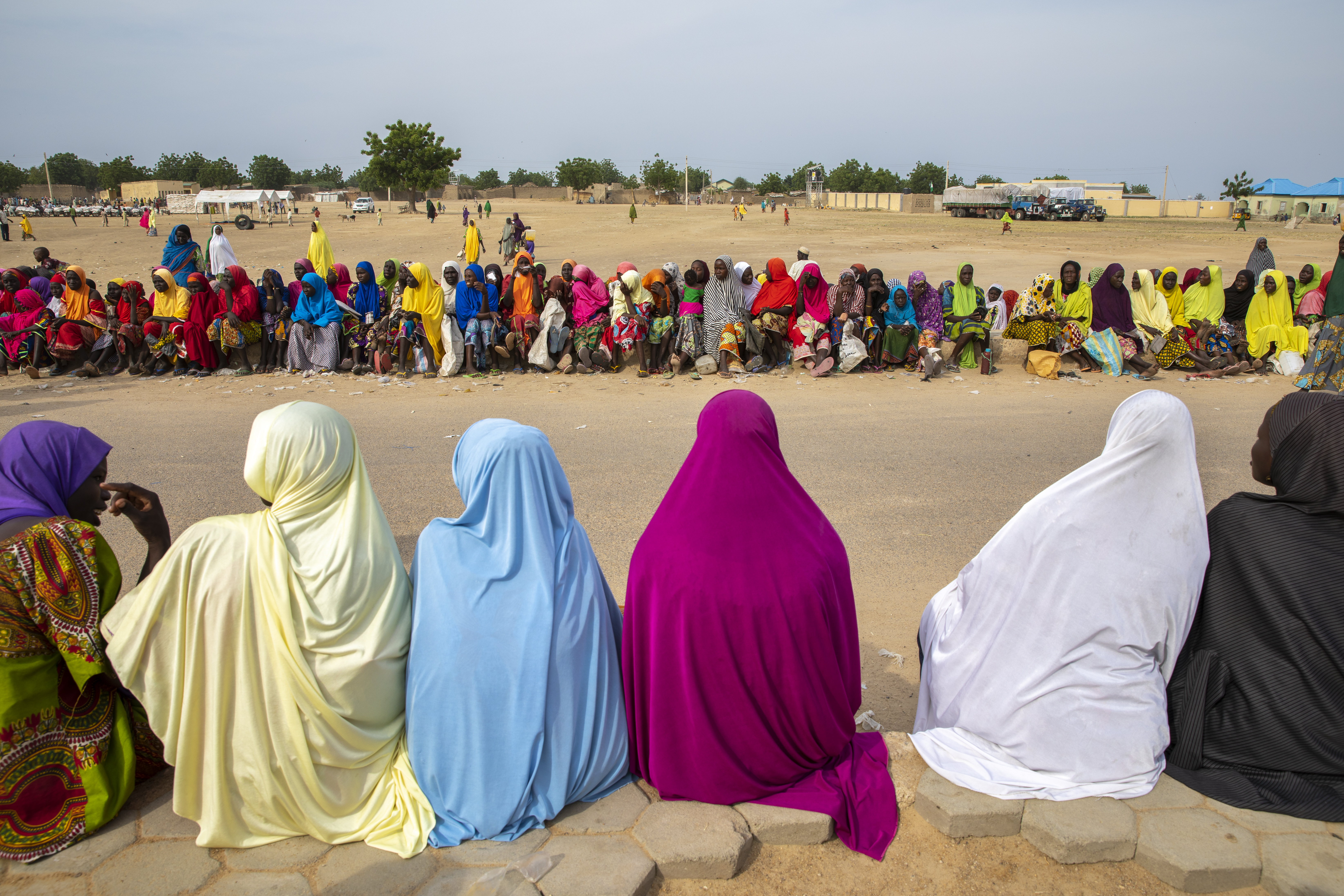 Women and children wait in line for a monthly food distribution in Fulatari camp.
