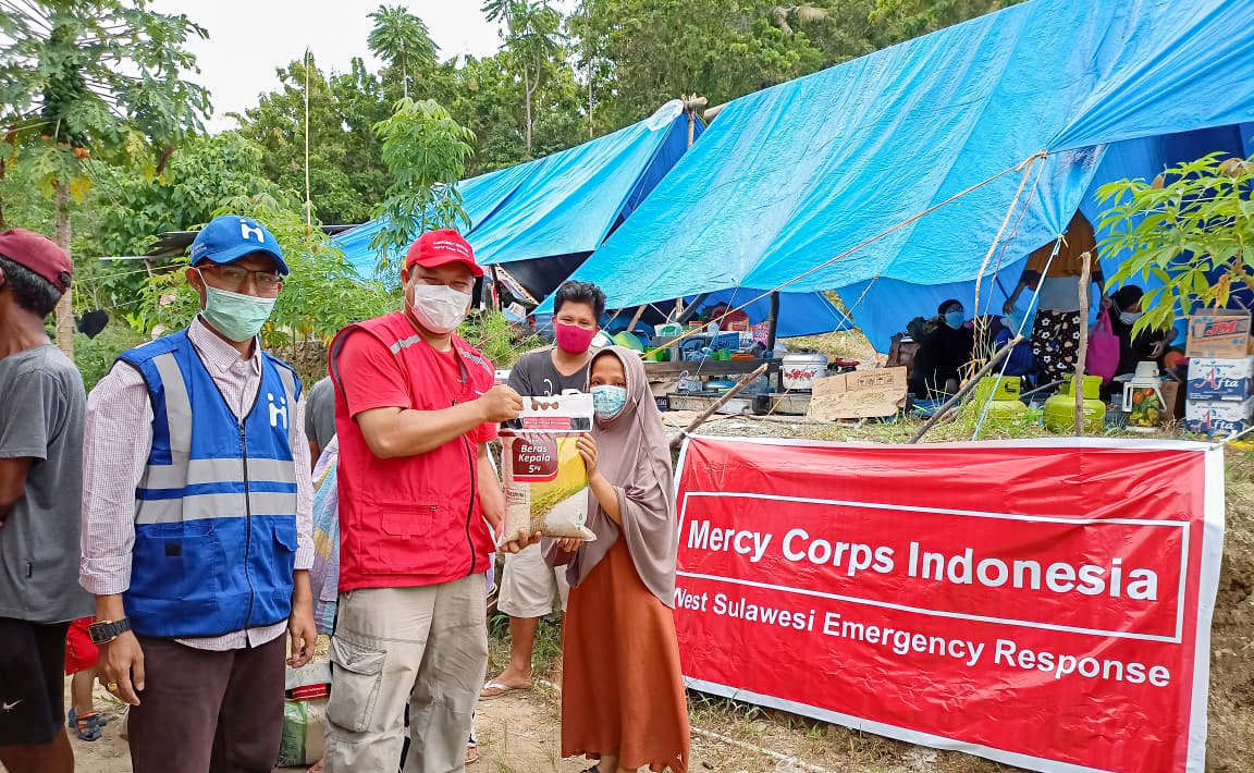 Humanitarian aid team members hand food to a participant.
