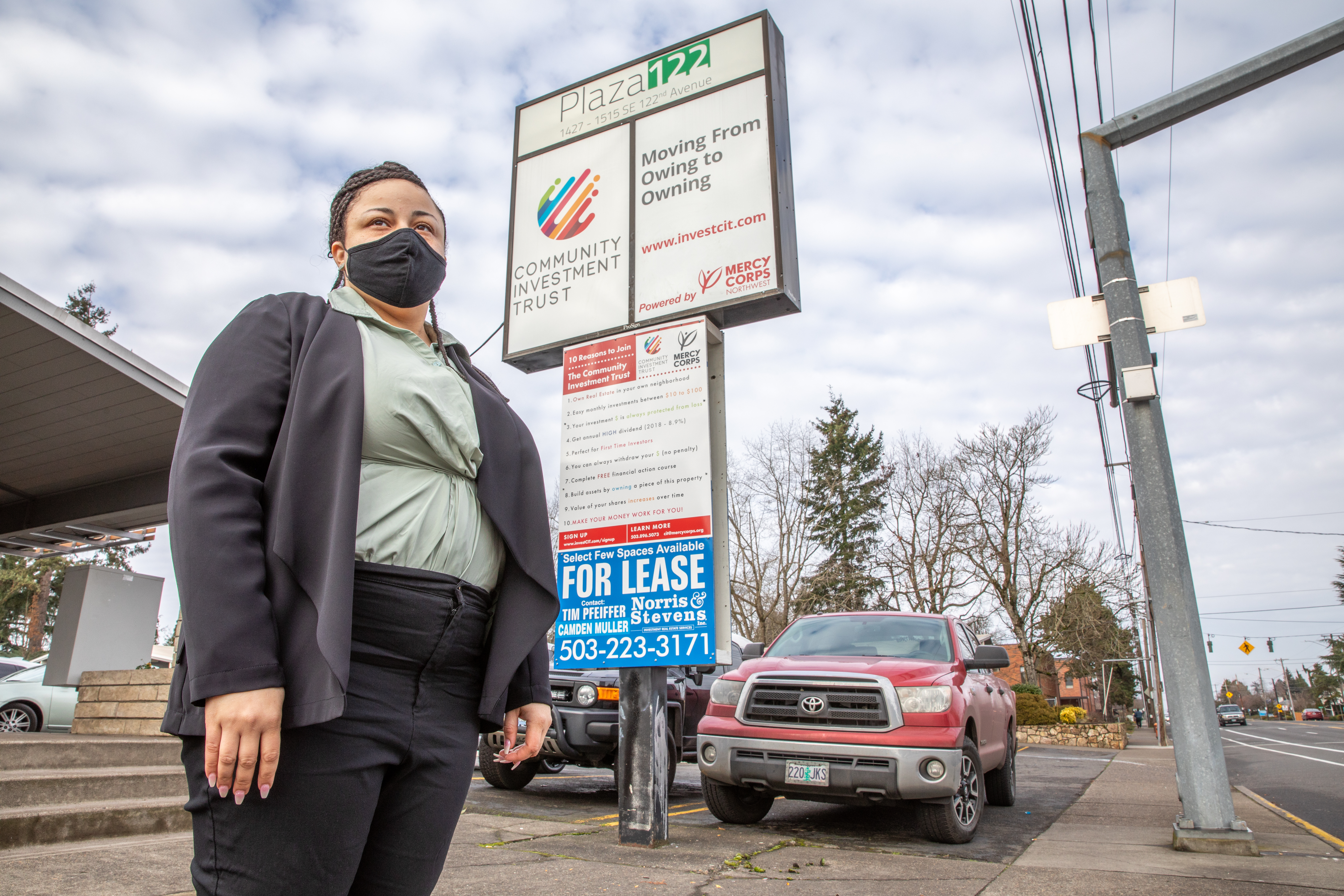 A person standing outside a neighborhood commercial-retail space. 