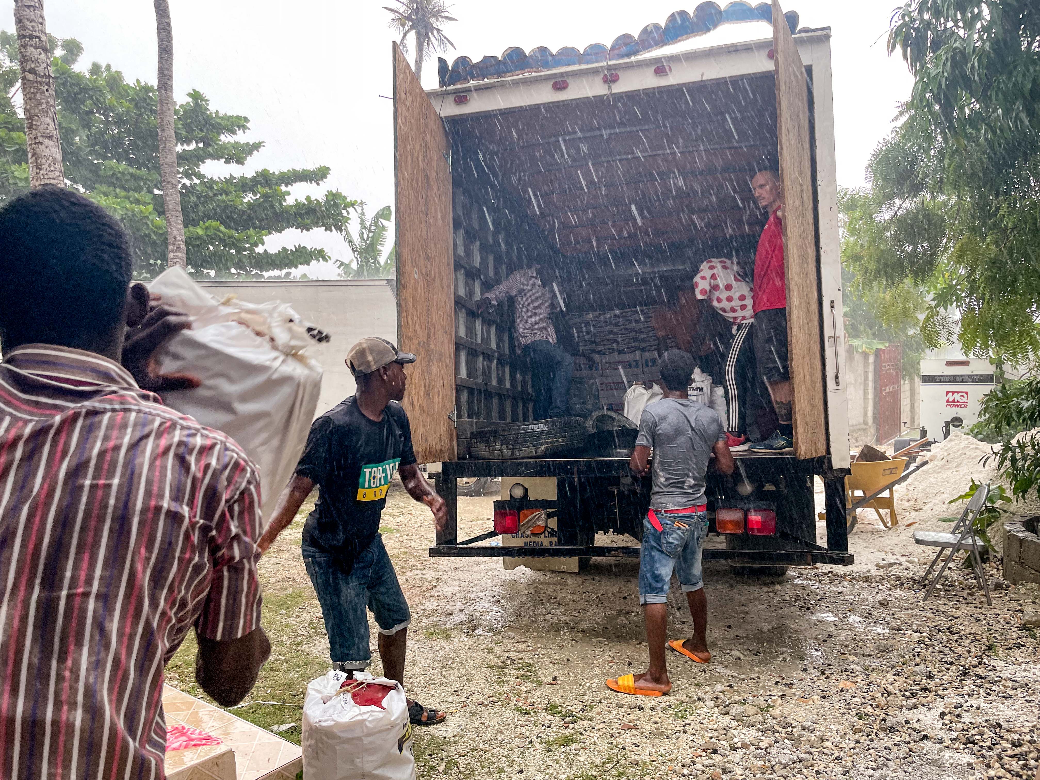 People unloading supplies from a truck.