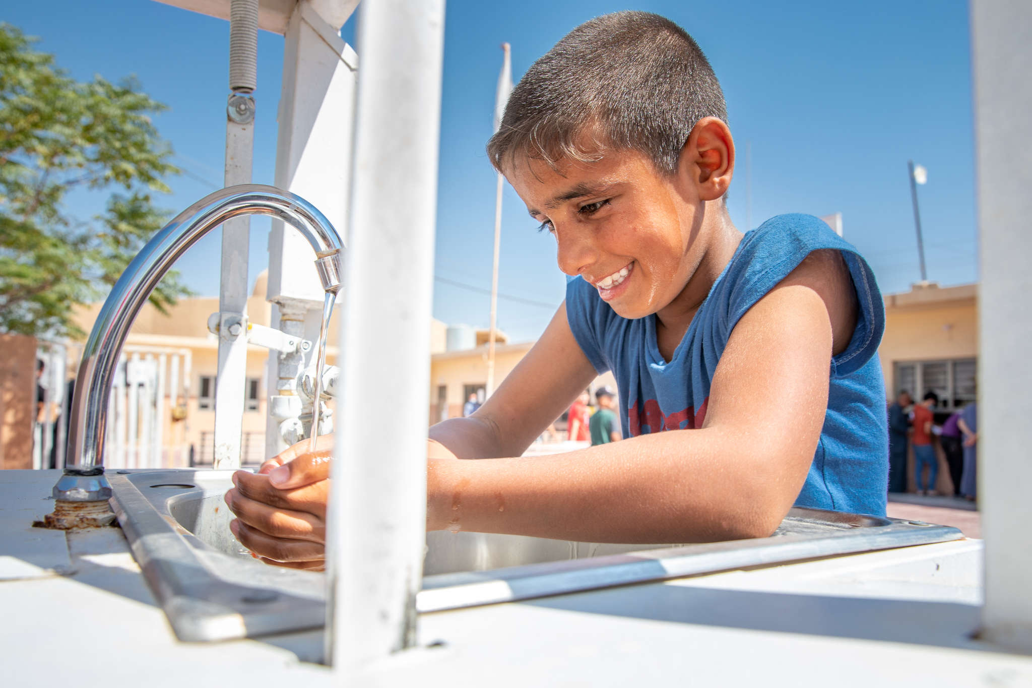A young person washing their hands.