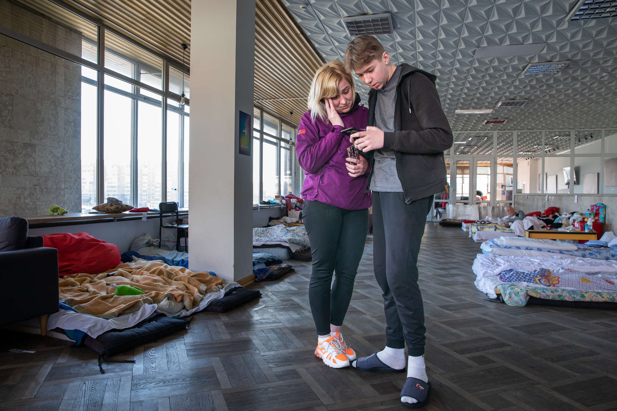 Two people reading a text message on a mobile device.