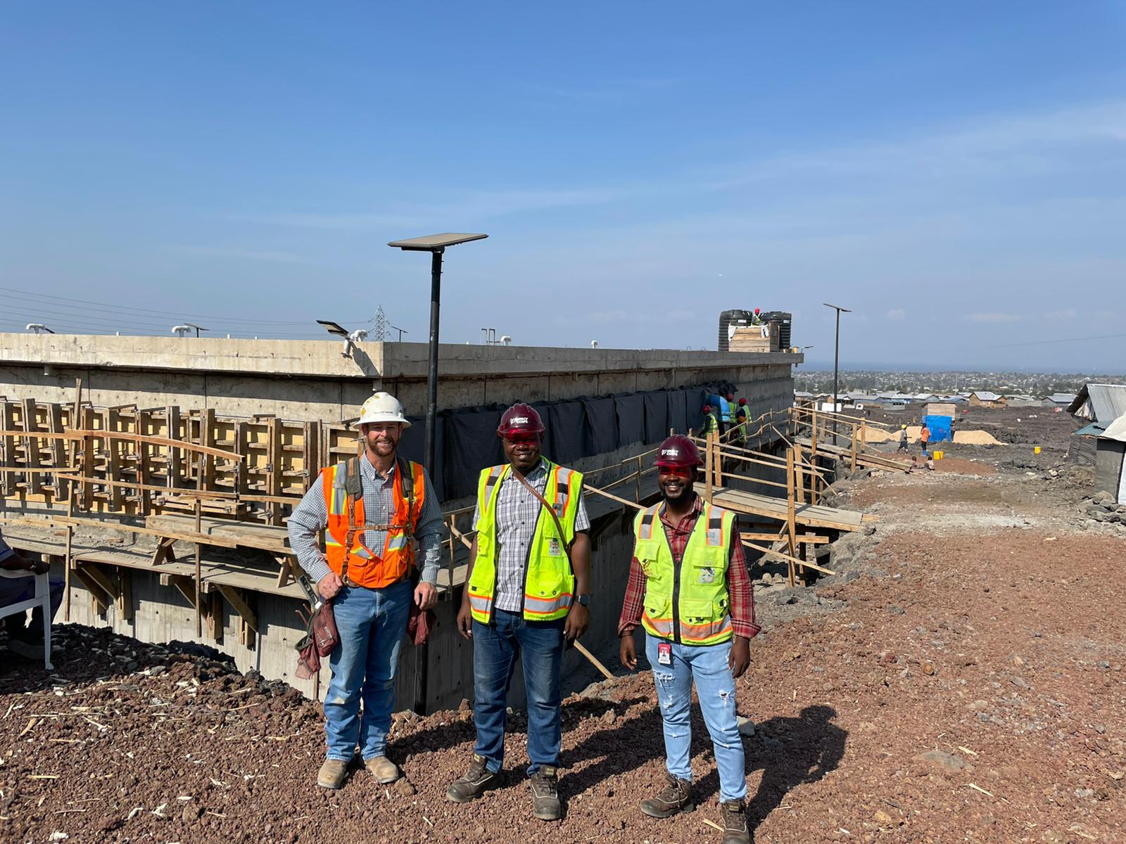 In DRC, three members of the Mercy Corps’ infrastructure team pose together, including engineer Simeon Kakule (center).
