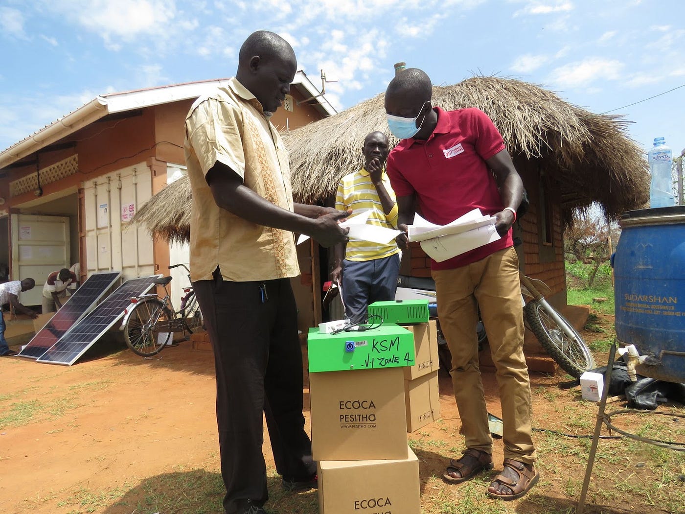 A mercy corps member reviewing a participtants paper work in uganda’s bidi bidi refugee settlement.