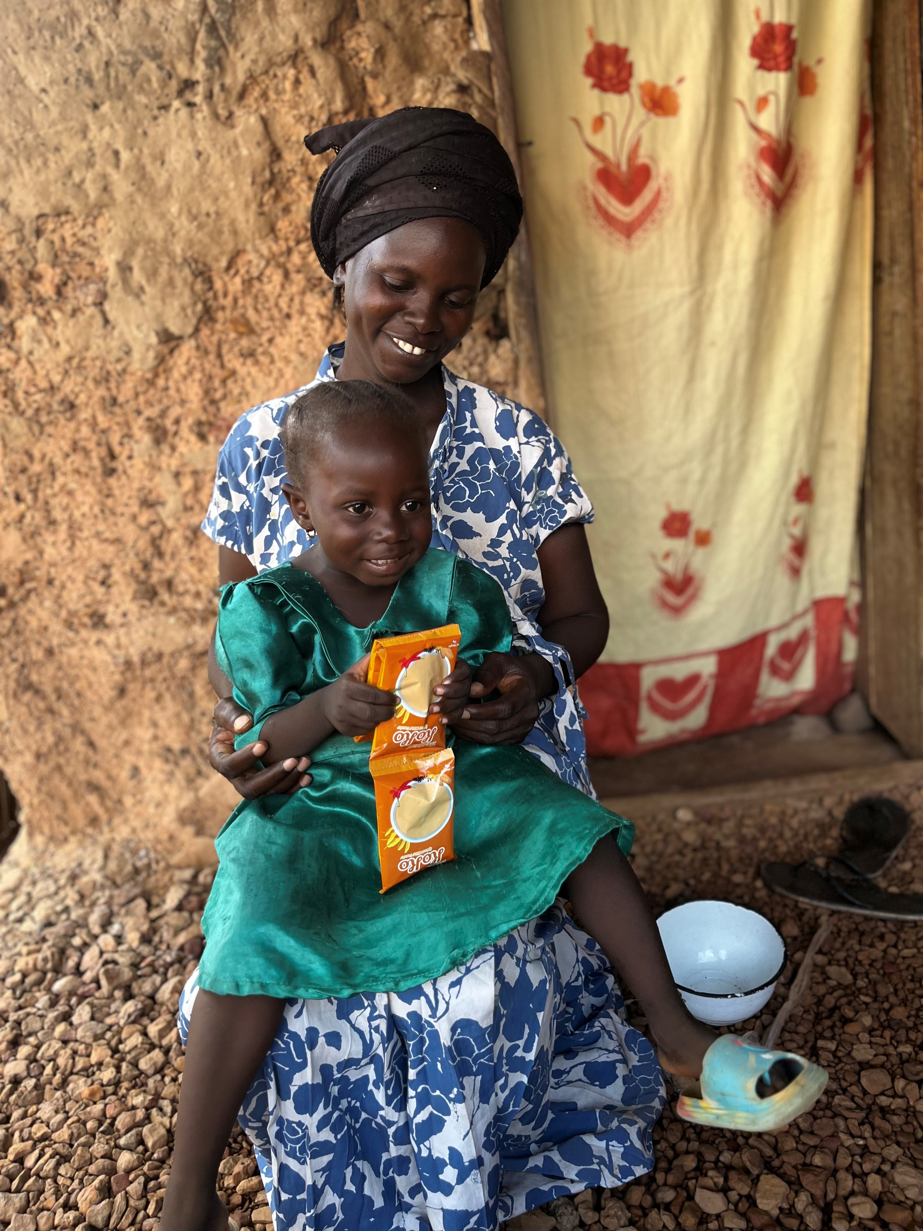 a seated mother holding her small child