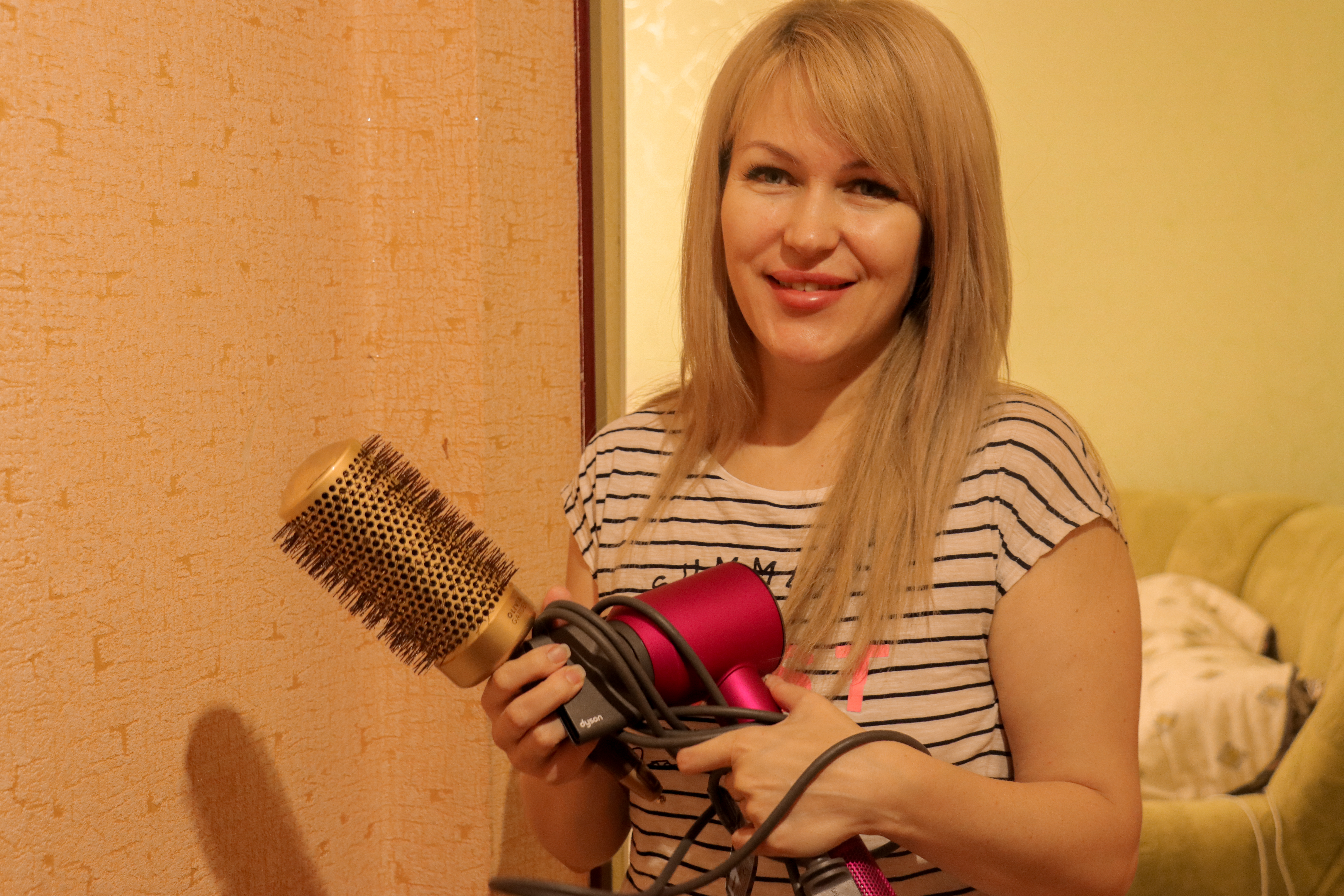 Woman standing with brush and hairdryer