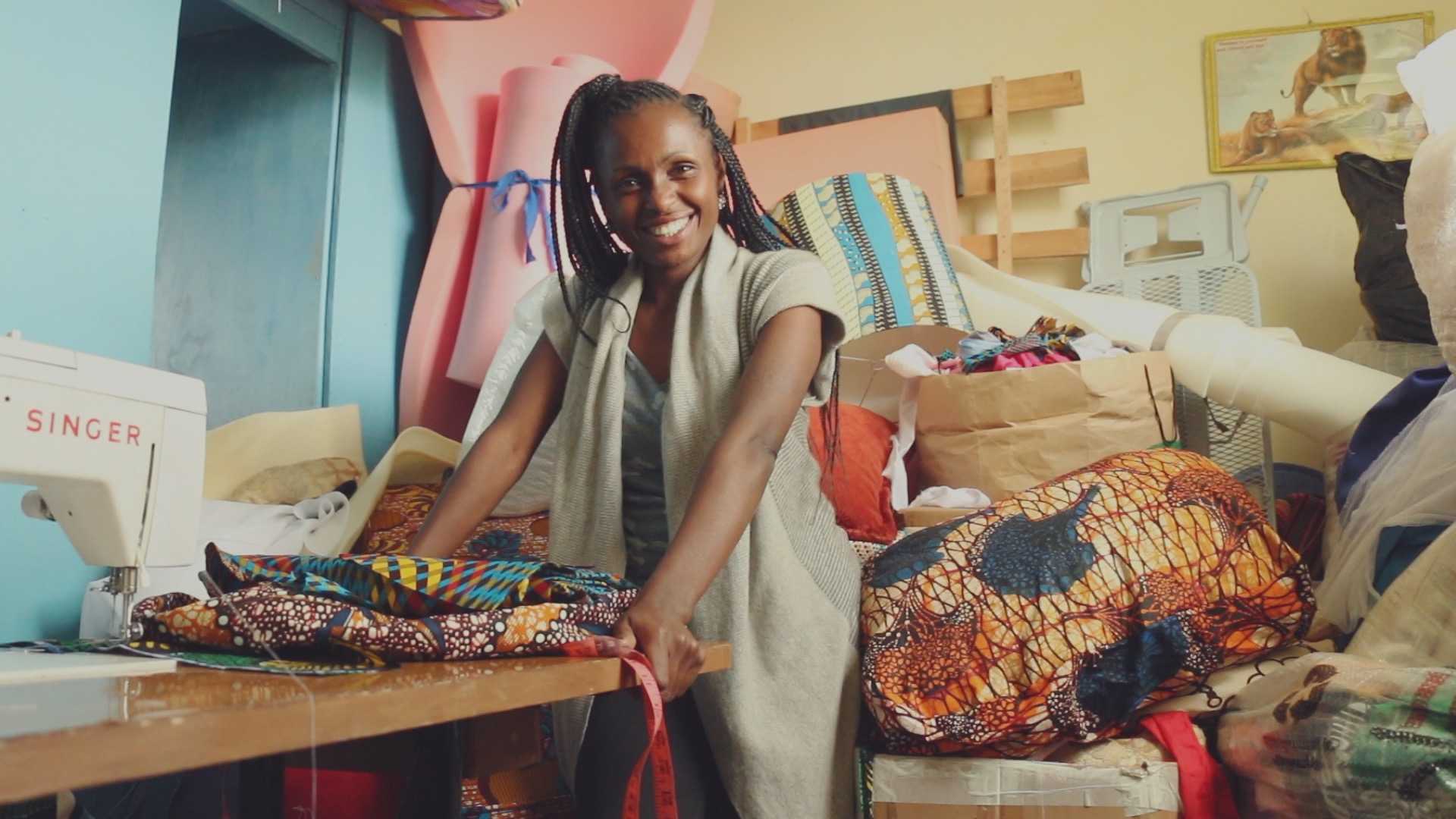 woman at a sewing machine smiling at the camera