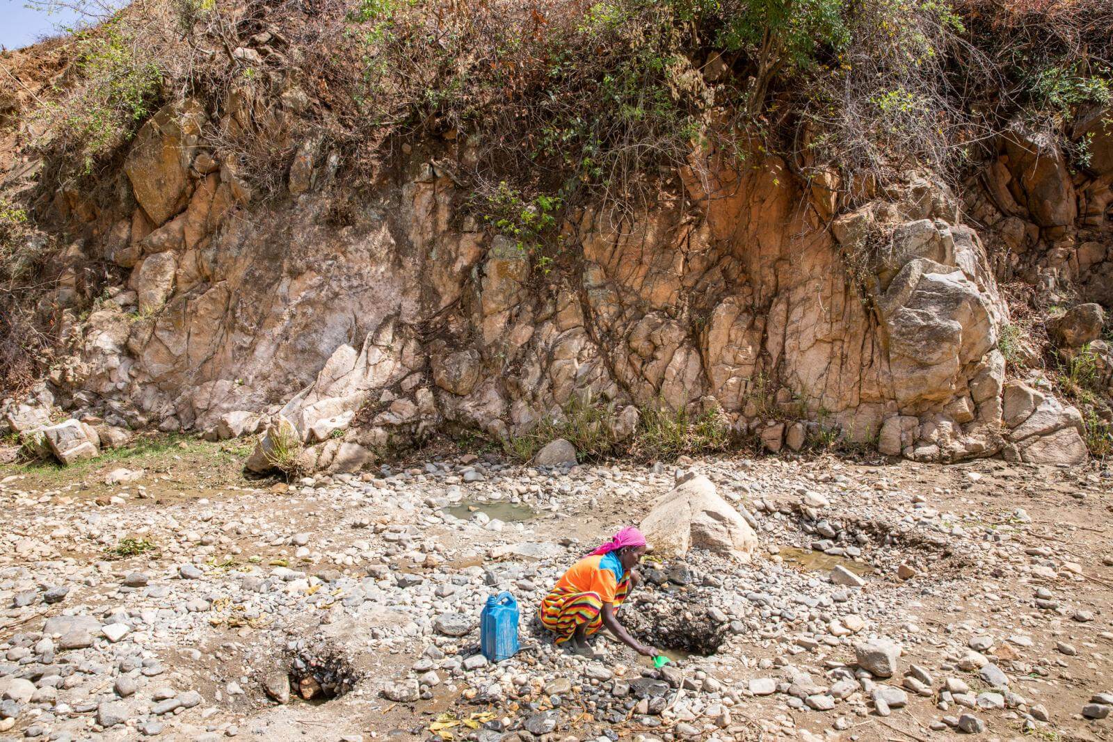 A woman gathering water at a rocky area in ethiopia