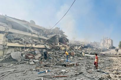 Palestines standing outside a destroyed building. Photo: ©Shadow Pro for Mercy Corps.