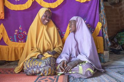 A mother and daughter sitting in their home.