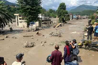 Residents look at partially submerged houses after a massive flood in Nepal.