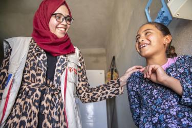 Mercy corps team member speaks with the daughter of a family of syrian refugees