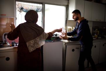 Bashar pictured in his kitchen with a woman to his left