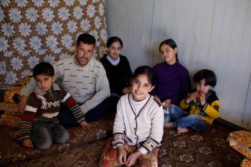 Family sitting together on a patterned carpet