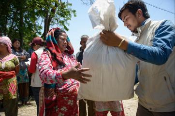 A woman in red receiving a bag of supplies