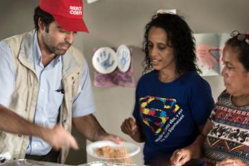 A mercy corps team member serves food to community members