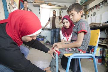 Woman in jordan adjusting a student's chair