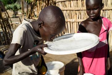 Boy drinking water from plate