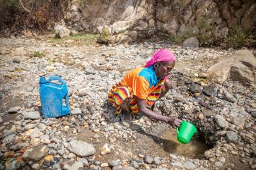 Manase gathering water from a riverbed