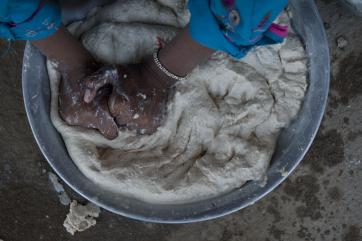 Hands kneading a bowl of dough in pakistan