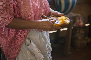 A woman carries a bowl of hearty, traditional soup in guatemala