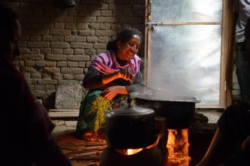 A woman cooks over a hot stove in nepal