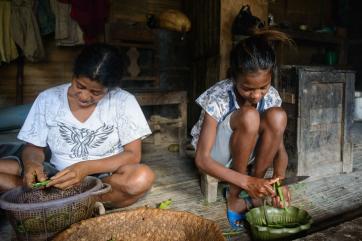 A girl and her older female relative prepare dinner