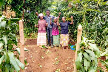 A family poses in celebration inside of their permagarden,