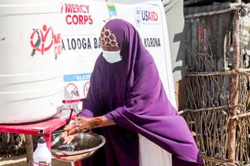 A person uses a hand washing station in somalia. 