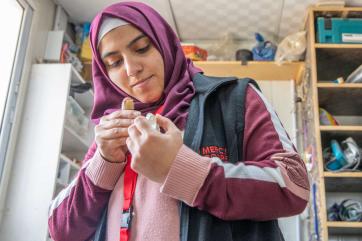 A person puts together a new prosthetic hand.