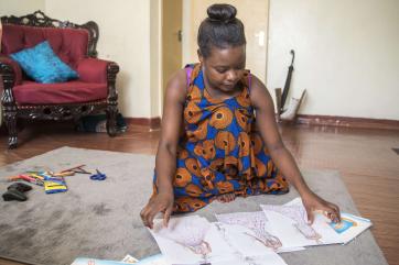 A fashion designer looks through some of her sketches on the floor of her apartment in the pangani area of nairobi. 