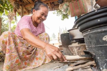 A person adjusting wood in their stove.