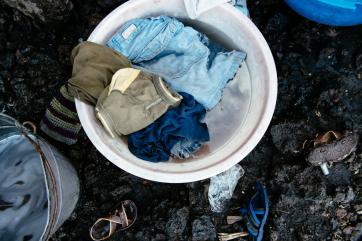 Articles of clothing ready to be washed in a bowl of soapy water.