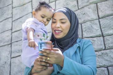 Jordanian mother and child looking at a phone.