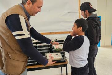 A lebanese man distributes hot meals to lebanese boys