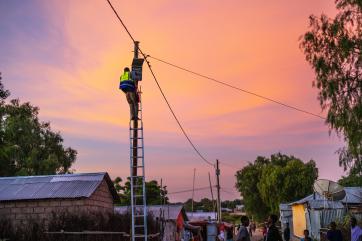 A solar technician installs a new connection to the power system. 