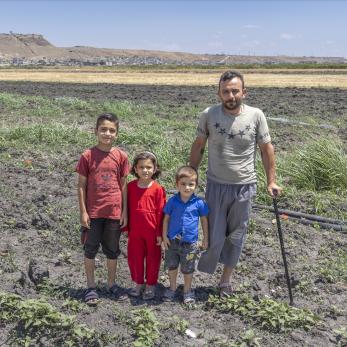 Syrian family standing in their farm.