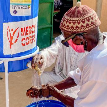 Niger man washed hands at portable washing station.