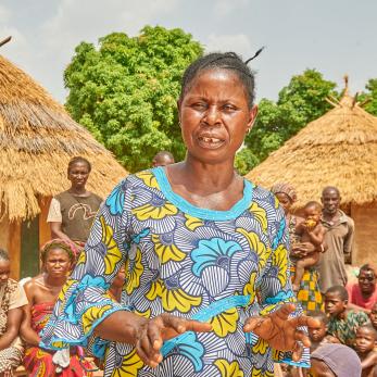 A farmer speaks to a large group of people.