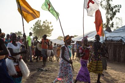 Group of people in south sudan walking and holding flags