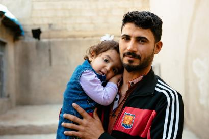 Father holding young daughter in iraq