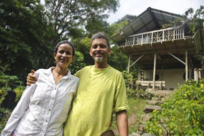 Woman and man standing in home garden with house in the background